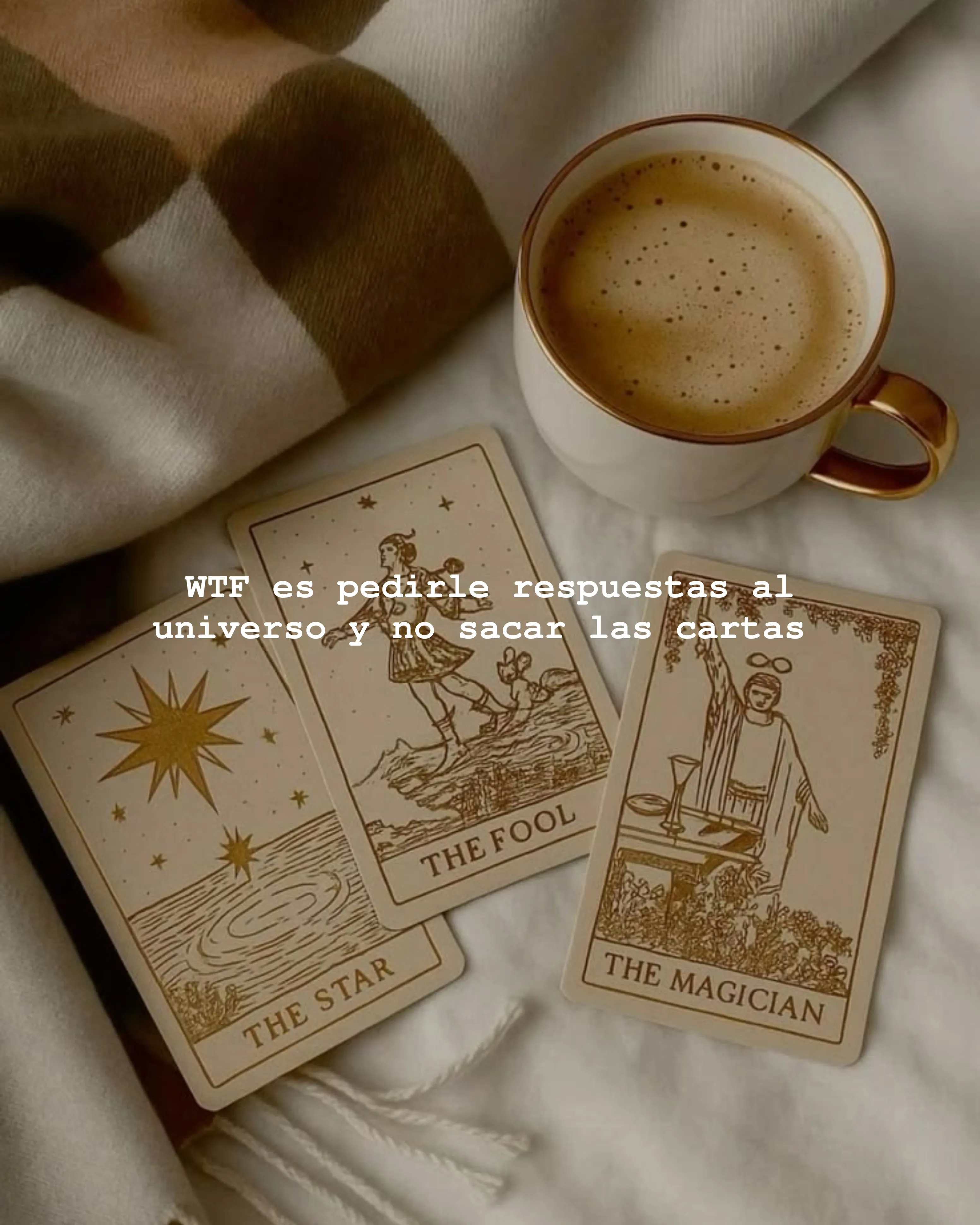 Taza de café junto a cartas de tarot sobre una manta